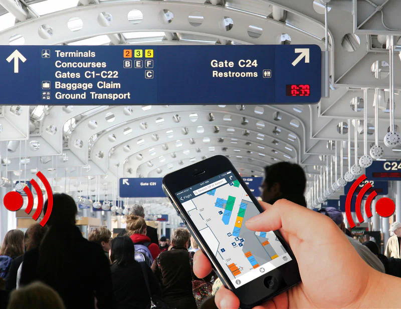 Airport terminal with a phone displaying a navigation map and beacon symbols