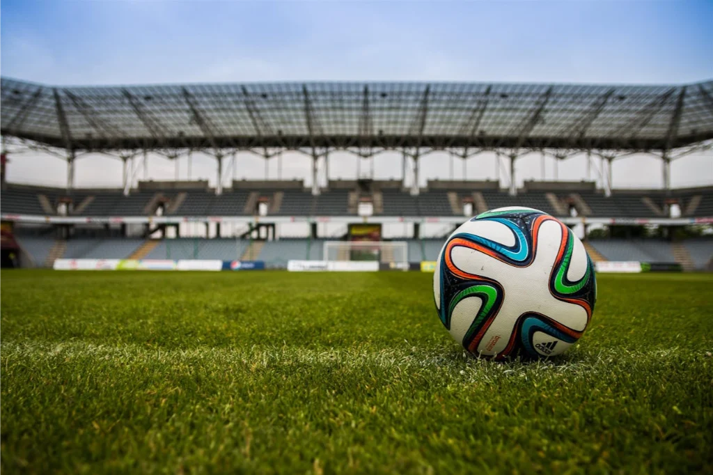 Football on a grass pitch representing a sports event