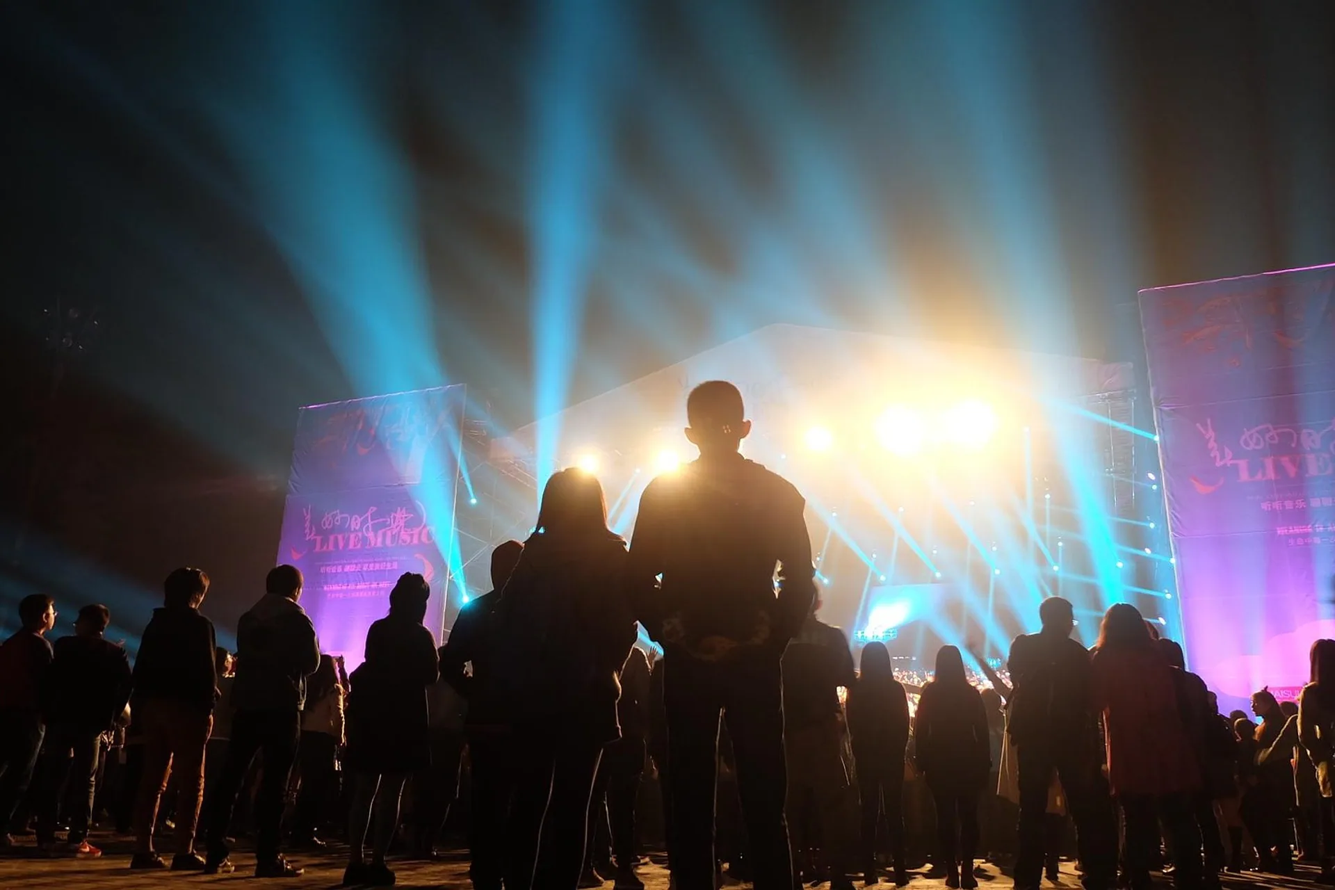 Audience at a live event under blue stage lights