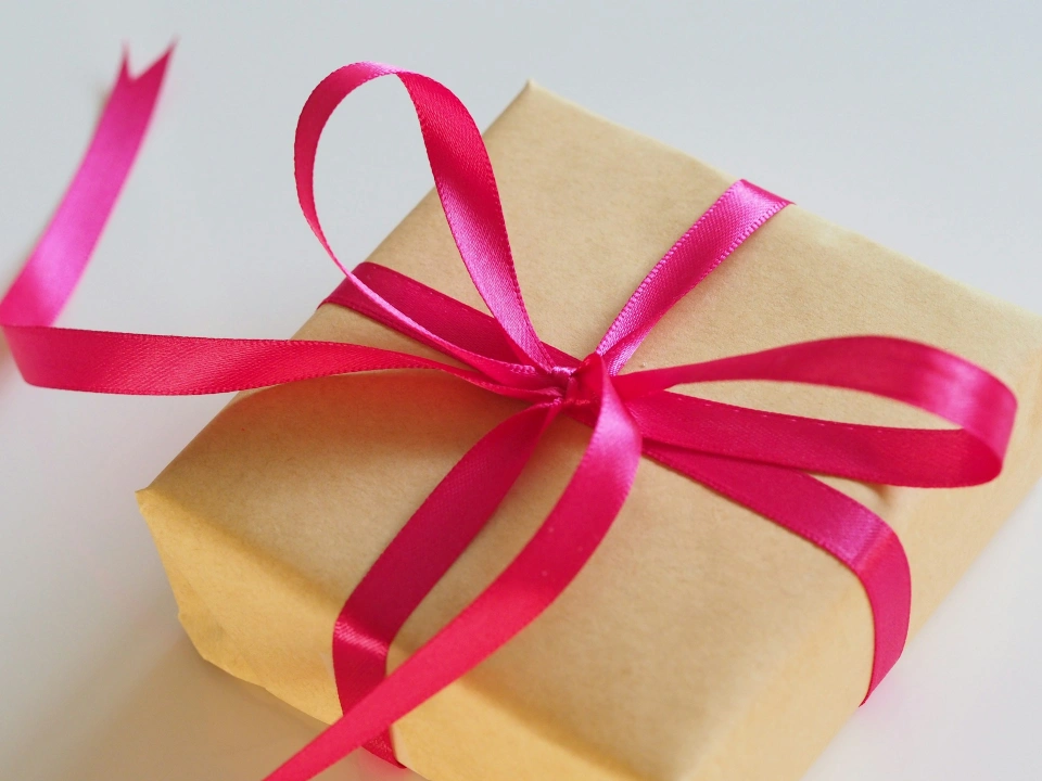 Gift wrapped in brown paper with a pink ribbon