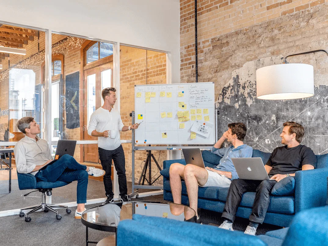 Team planning around a whiteboard covered with notes