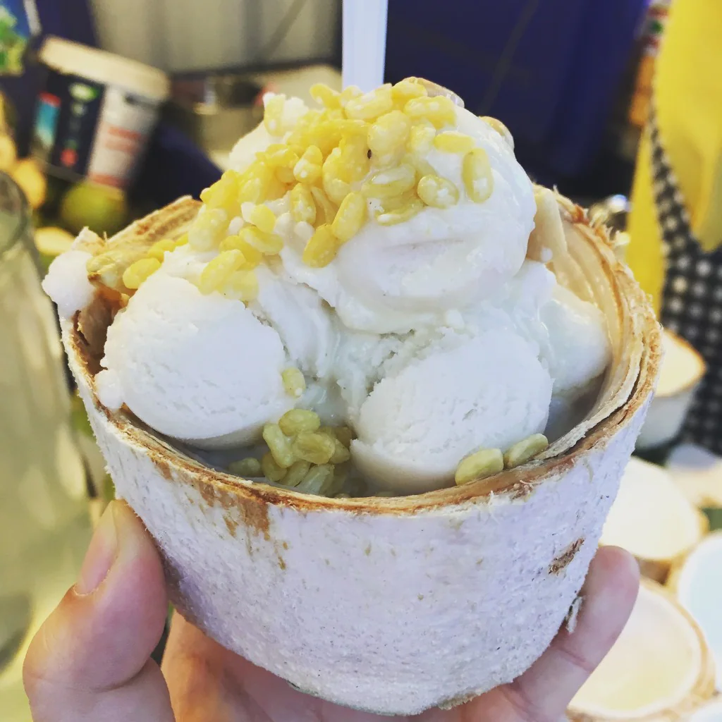 Coconut ice cream topped with corn and served in a coconut shell