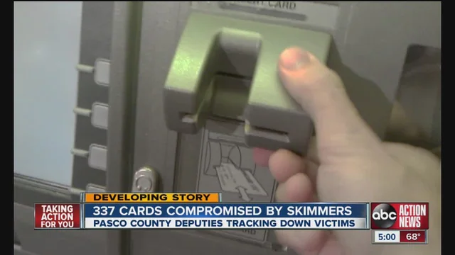 News report showing a card-skimming device held near a payment reader
