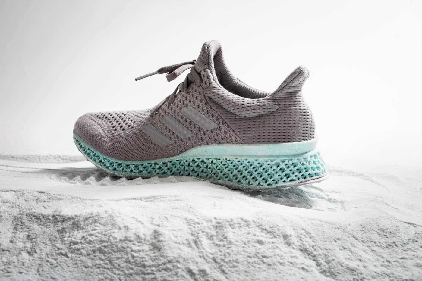 Grey Adidas shoe with a turquoise 3D-printed lattice midsole