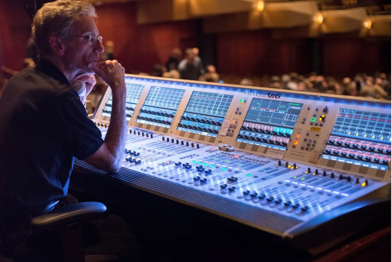 Sound engineer operating a mixing console at an event