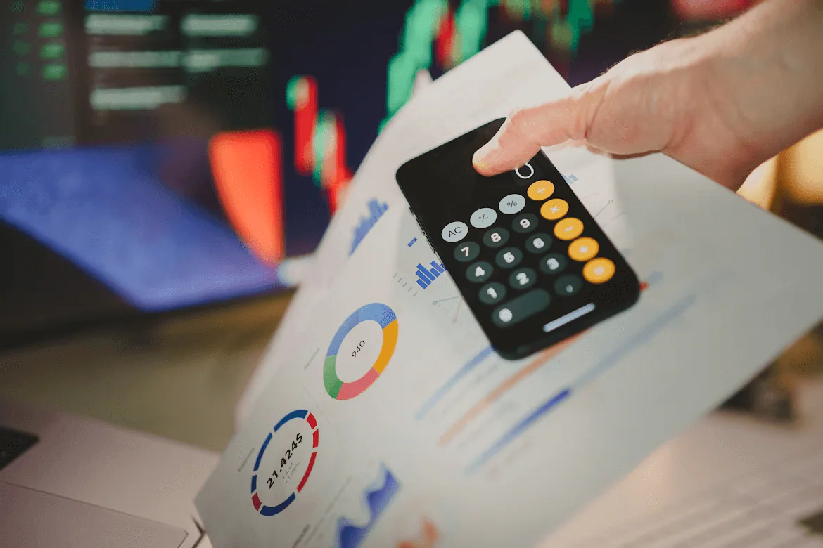 Hand using a calculator over financial reports