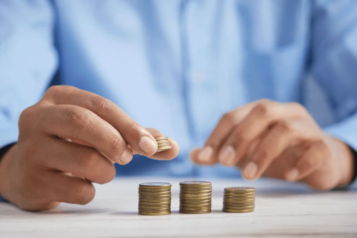 Person stacking coins to illustrate budgeting and cost savings