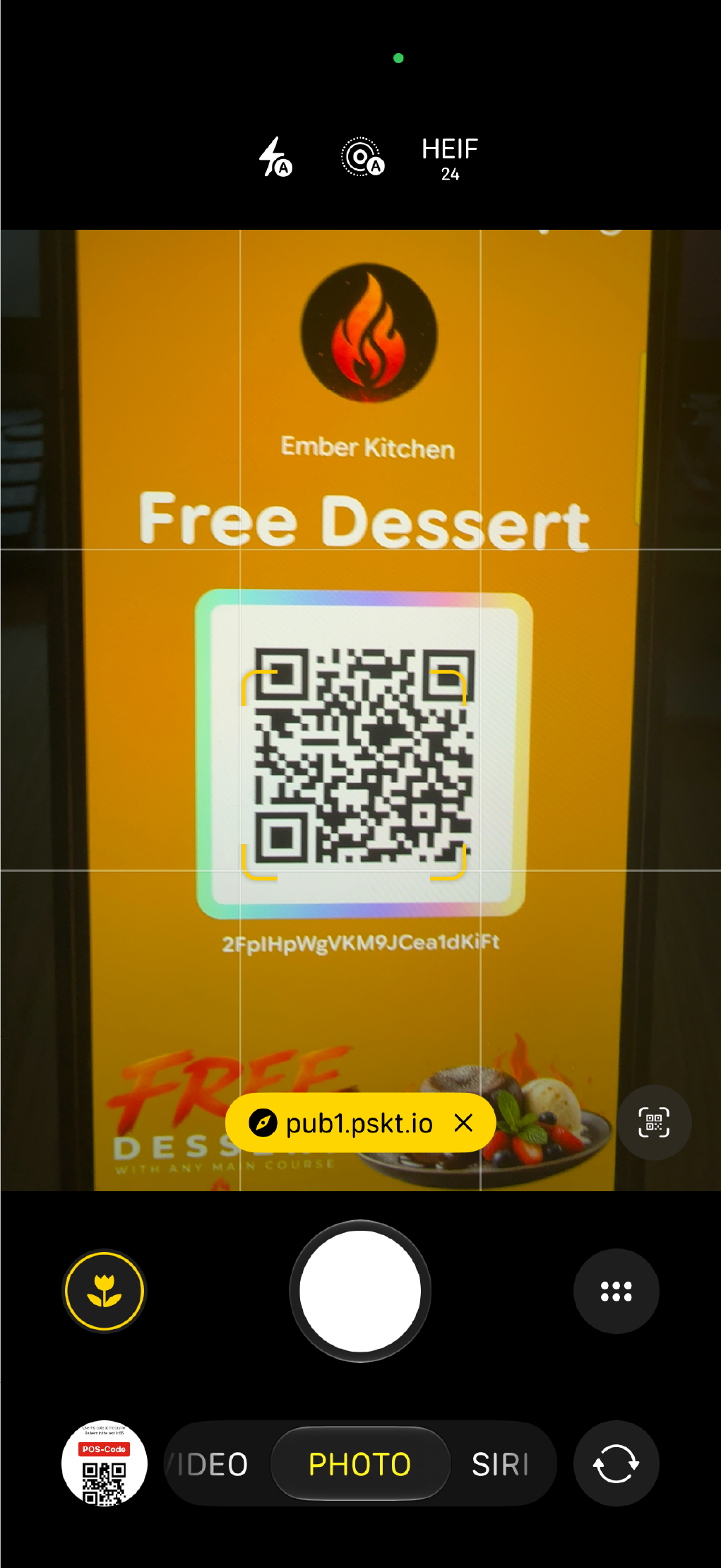 A smartphone camera scanning the QR code on a Free Dessert wallet pass.
